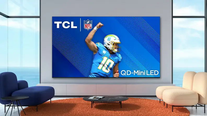The TCL QM8 mini-LED TV displaying a professional football player in a modern living room