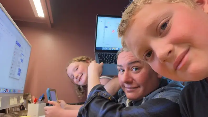 Author with her two kids at a computer desk