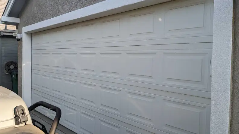 A cream colored residential garage door shown closed