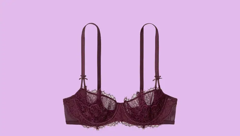 A burgundy bra against a hot pink background.
