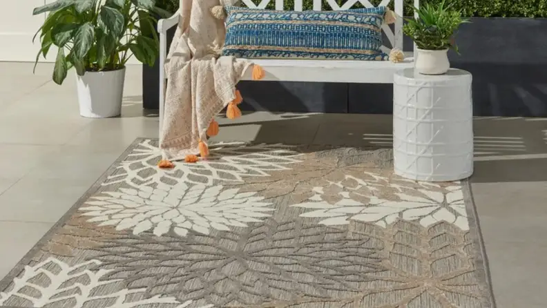 Grey and cream rug outdoors on ground next to stylish patio set-up