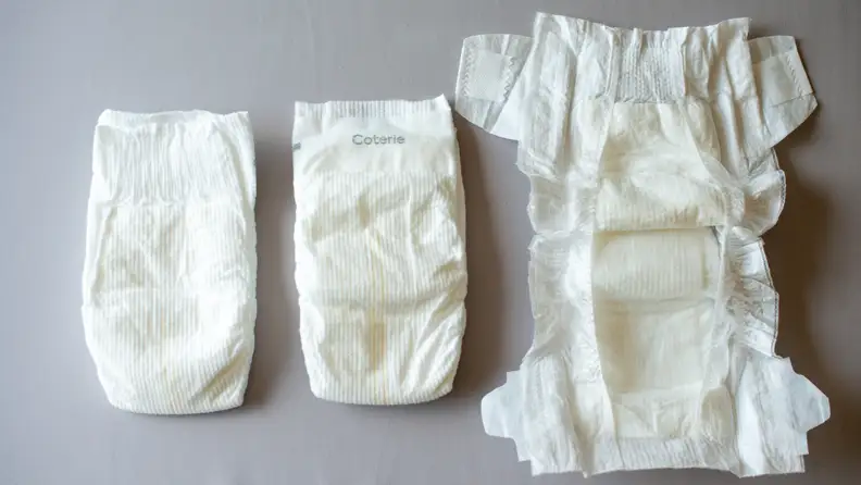 Three The Diapers by Coterie laying side by side, showing front, back, and open positioning.