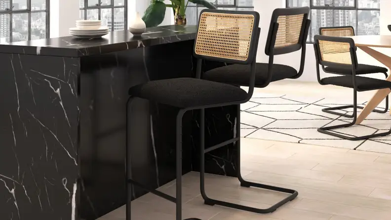 Black bars tools with rattan back in front of a granite counter