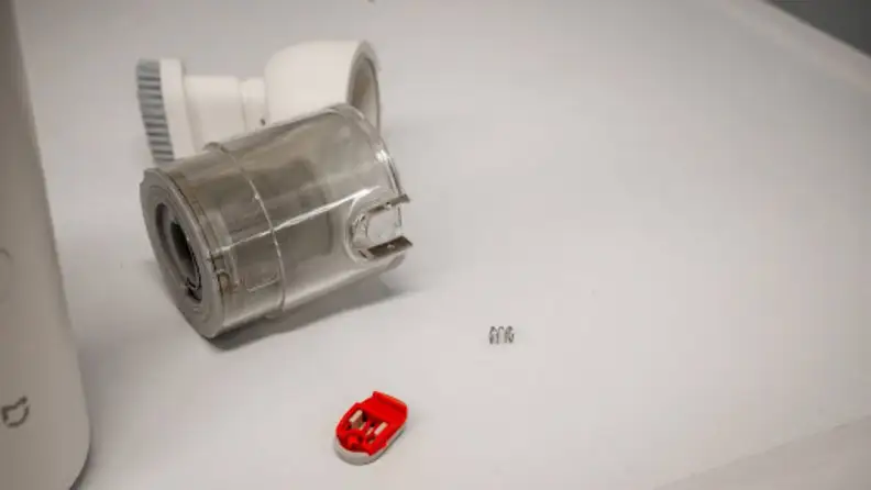 A broken dust cup with its switch and spring detached