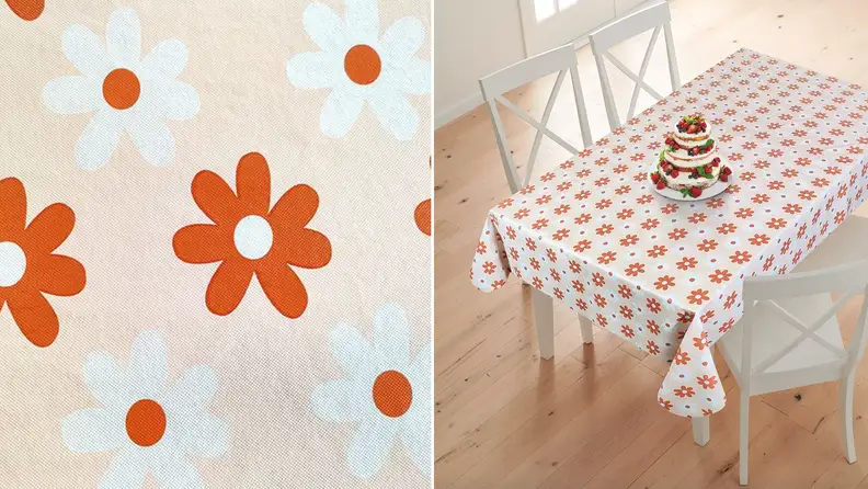 Product shot of orange and white floral printed tablecloth.