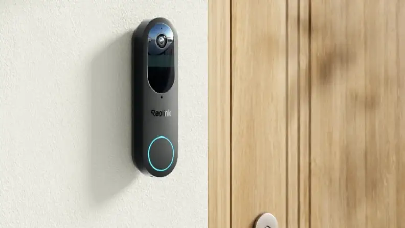 A video doorbell mounted to a wall next to a front door