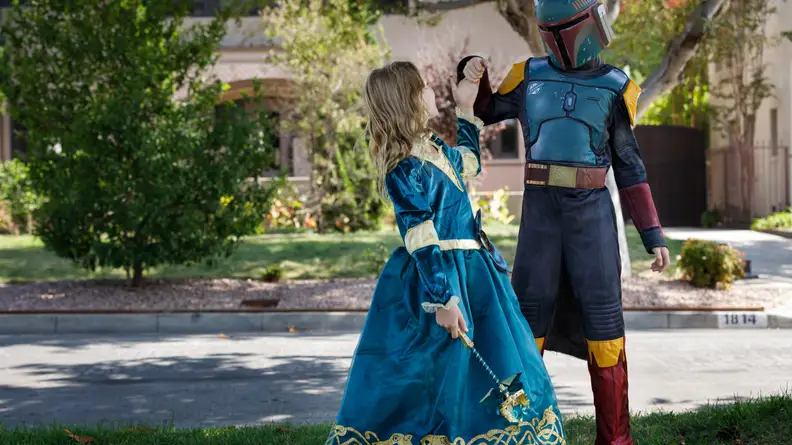 A child dressed in a Merida costume and a child dressed in a Boba Fett costume spar.
