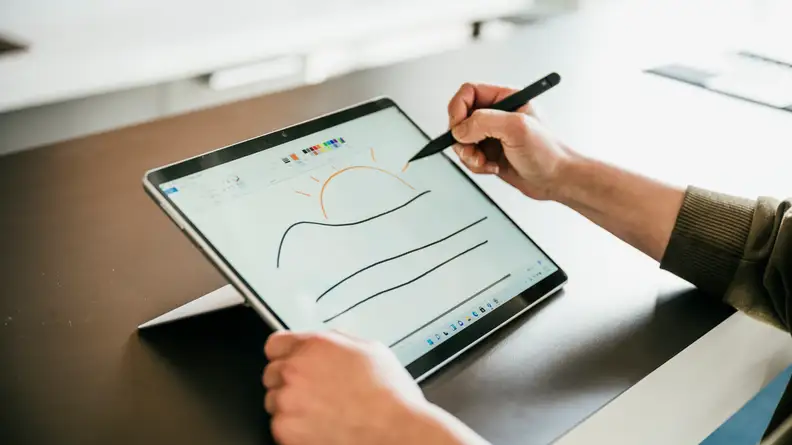 The Pro 8 in tablet mode, with someone drawing on it using Microsoft's stylus.