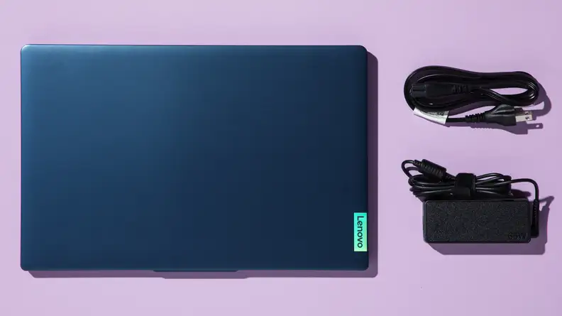A top-down view of a laptop and its charging accessories.