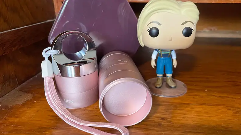 The Zannaki Metal Travel Pill Organizer next to a Funko Pop figurine