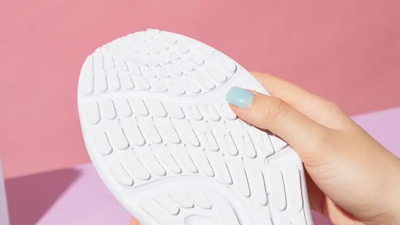 Person using their thumb to feel the sole on the lululemon Beyondfeel sneaker.