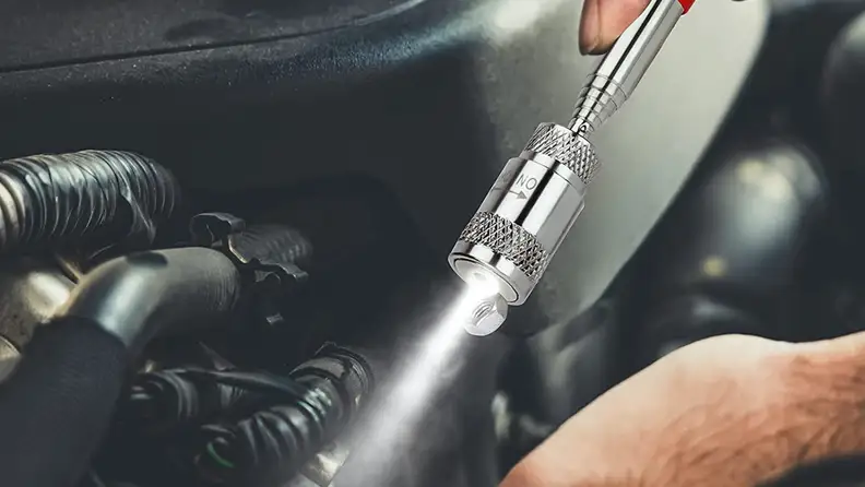 A person uses a magnet in the dark.