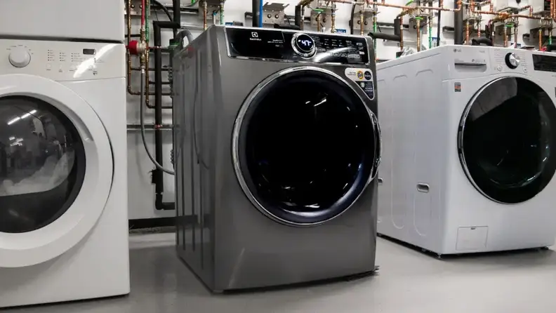 Front-load washing machine displayed in an appliance testing laboratory.