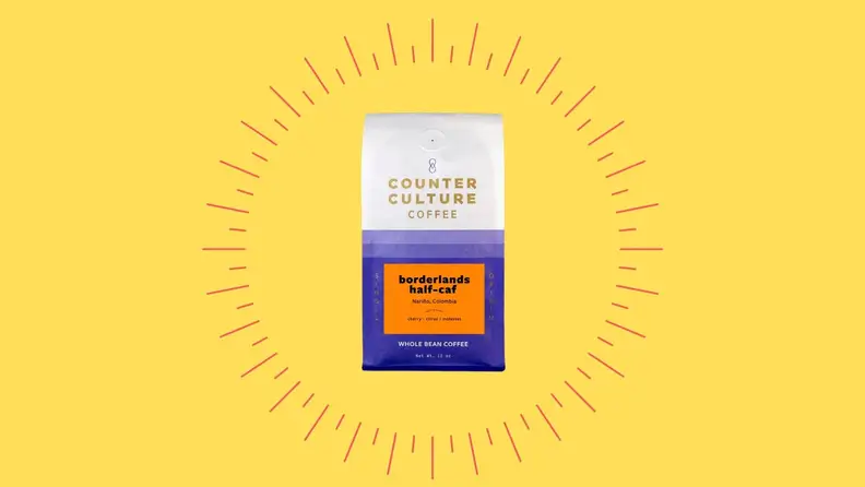 A bag of decaf coffee against a bright yellow background.