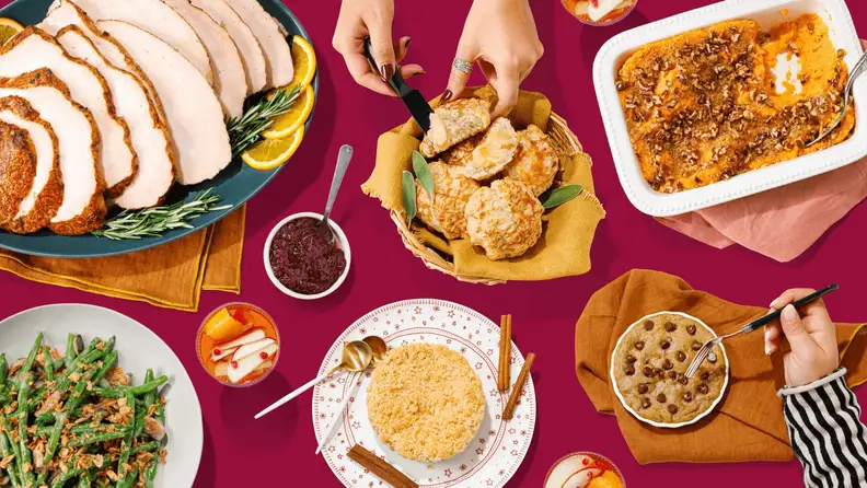 A spread of Thanksgiving dishes on a red table, shot from above
