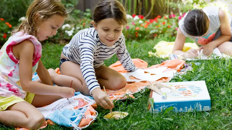 Two girls painting in the backyard