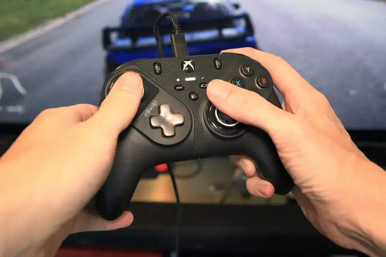 A pair of hands holding the controller to play video games.