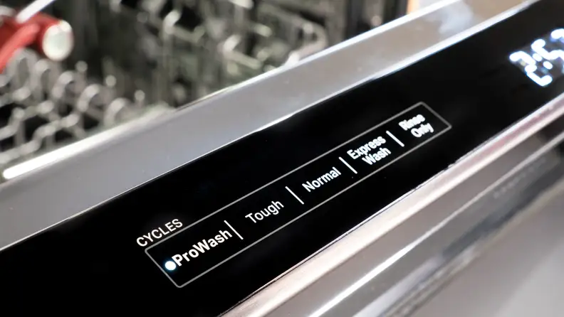 A close up of the KitchenAid KDPM804KBS dishwasher's controls, located along the top edge of its door.