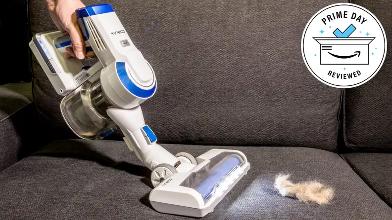 The Tineco A10 vacuum sucking up some pet hair on a couch.