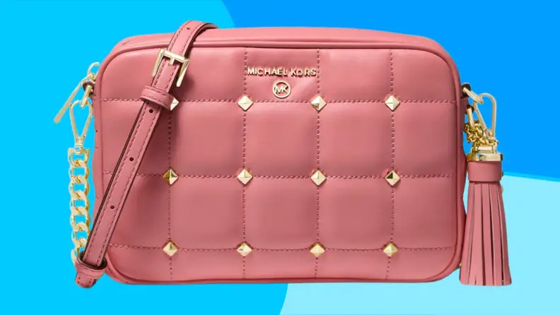 Pink leather crossbody bag in front of blue background.