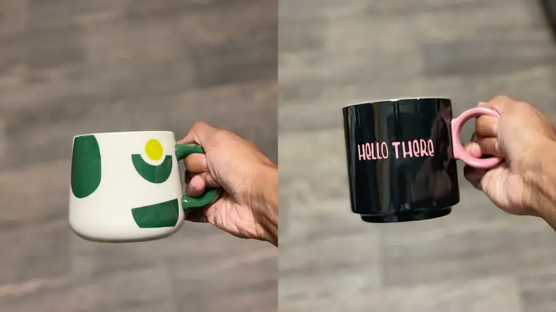Green, white, and gold avocado mug and black mug with 'Hello There' written in pink text by Tabitha Brown for Target