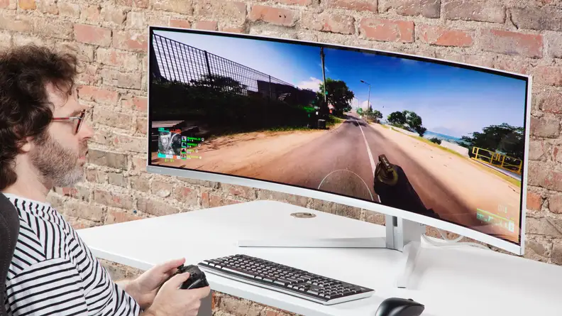 A person playing an FPS in front of the Philips Evnia 49M2C8900.
