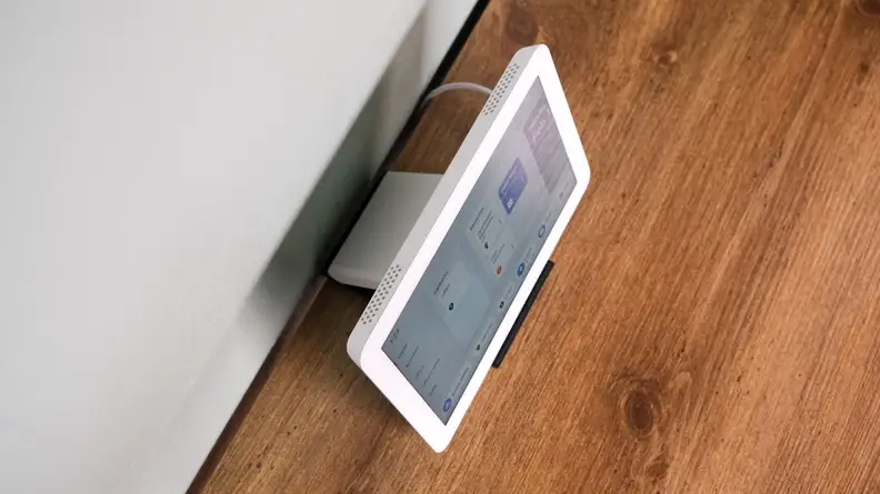 An overhead photo of the  Amazon Echo Hub with the screen set to on, sitting on a wood table.