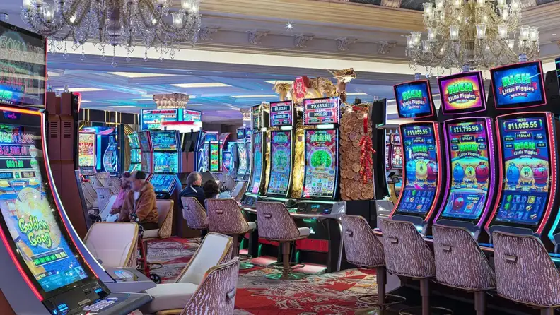 Two pairs of senior couples playing the slot machine at a casino