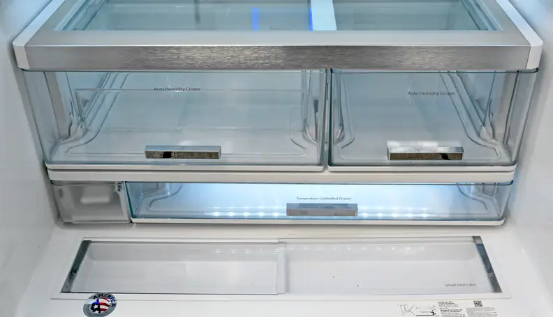 The fridge comes with asymmetrical crispers, a temperature adjust drawer underneath, and two recessed nooks right in front. The water filter is also found in the lower left corner.