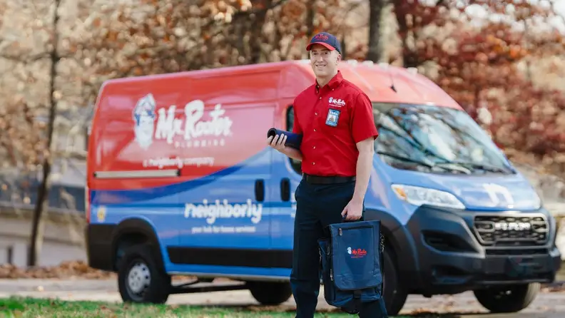 Technician holding equipment bags in front of a service van