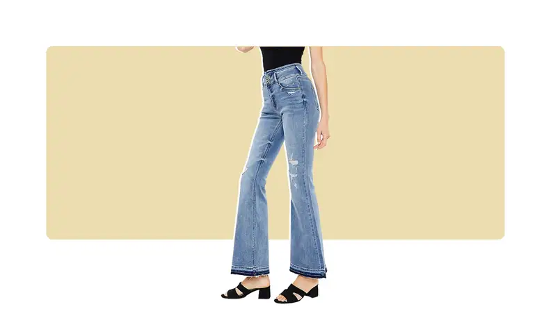 A model seen from the waist down, wearing flared jeans with black shoes.