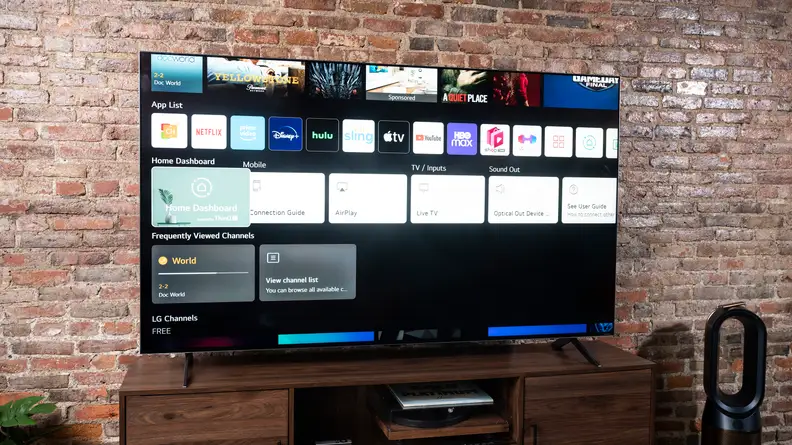 The LG QNED99 8K TV displaying its smart platform's home screen in a living room setting