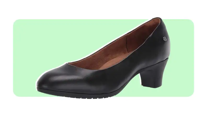 A black high heel shoe with slip-resistant tread on a green and white background