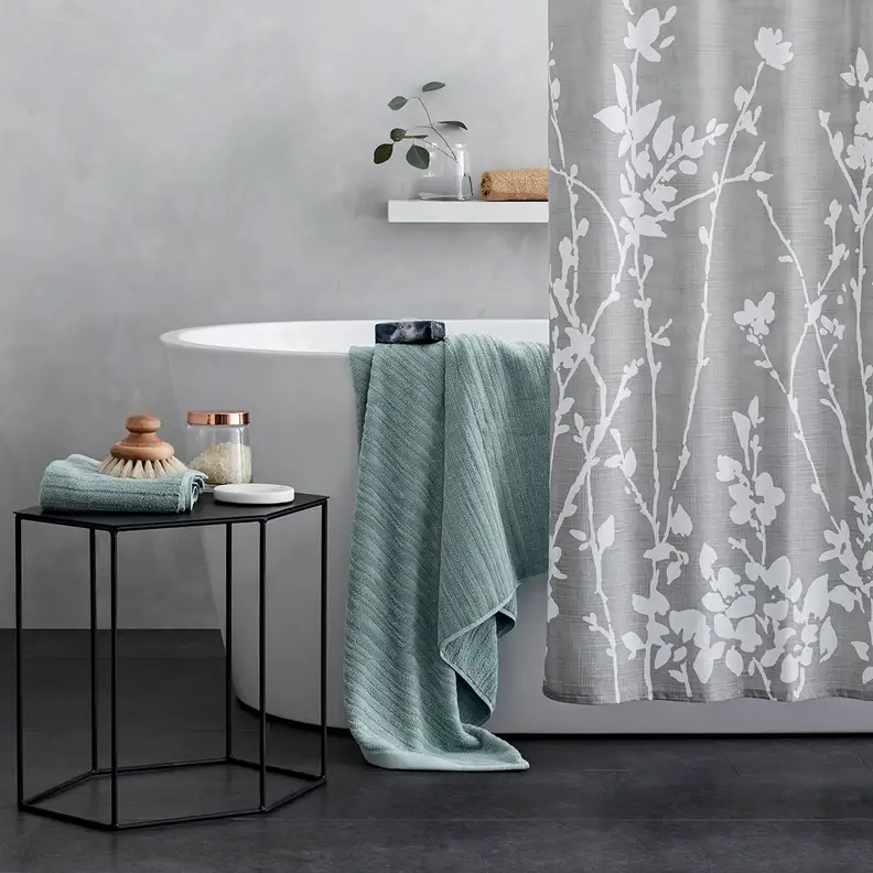 A gray and white shower curtain looks fresh