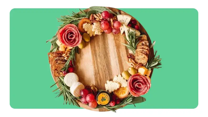 A cutting board with snacks making up a wreath on top.