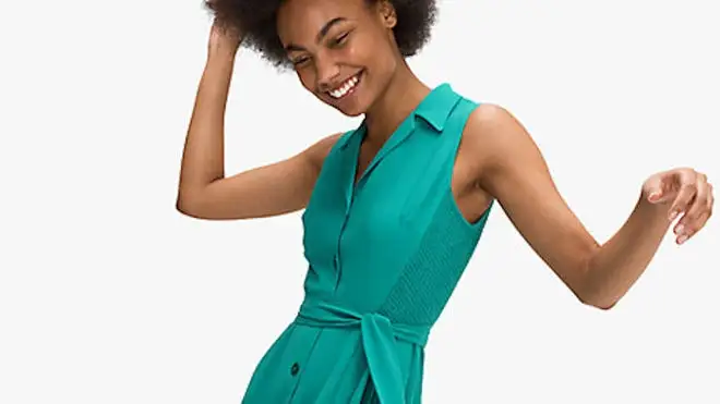 Woman smiling while wearing teal Kate Spade dress