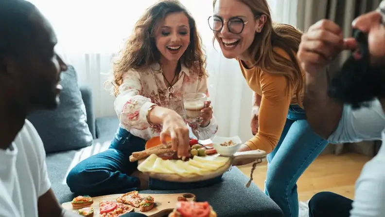 Friends sharing a cheese board at home