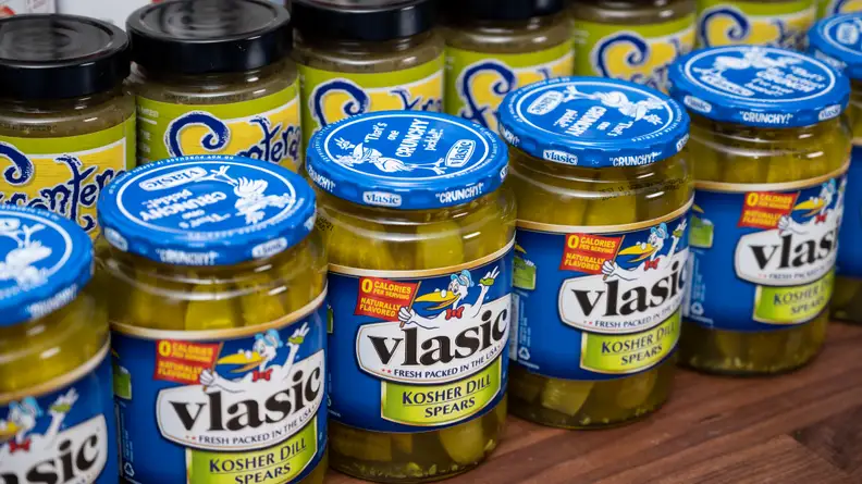 A collection of Vlasic dill-pickle spears and salsa jars.