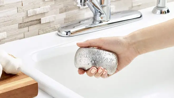 Person holding AMCO metal bar over sink