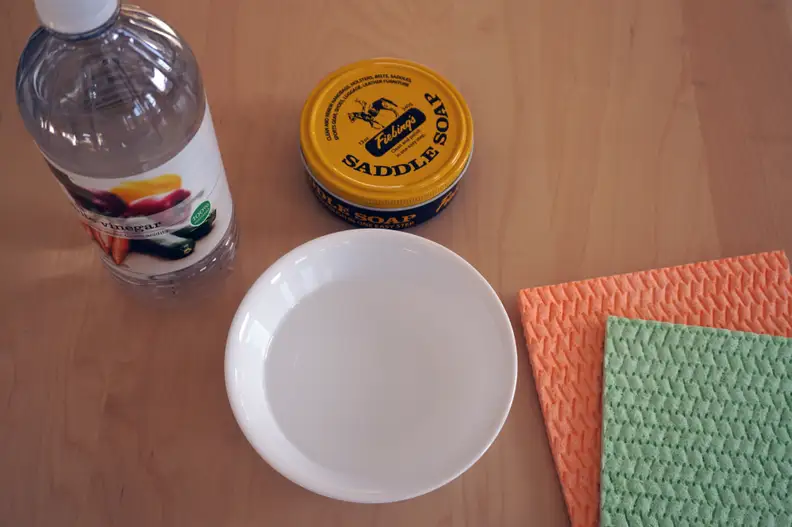 Water, vinegar, cloths, and saddle soap