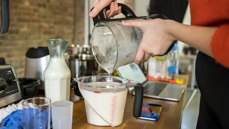 Pouring almond milk out of the Instant Pot Blender