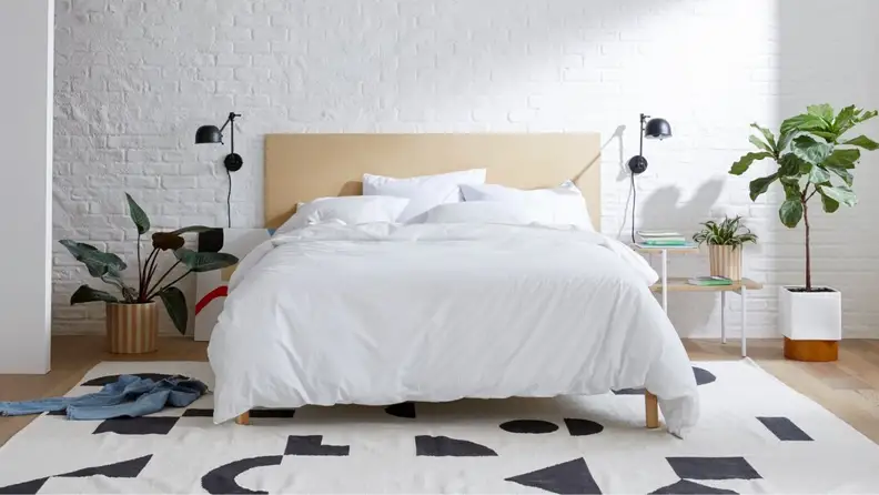 a bed with a white sateen bed spread