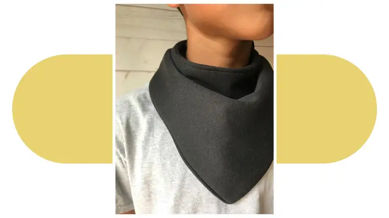 Close-up of a person wearing a green Droolist bib around their neck.
