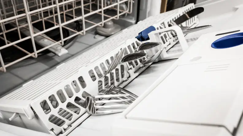To get the most out of the lower rack, you have to hang the cutlery basket off the door.