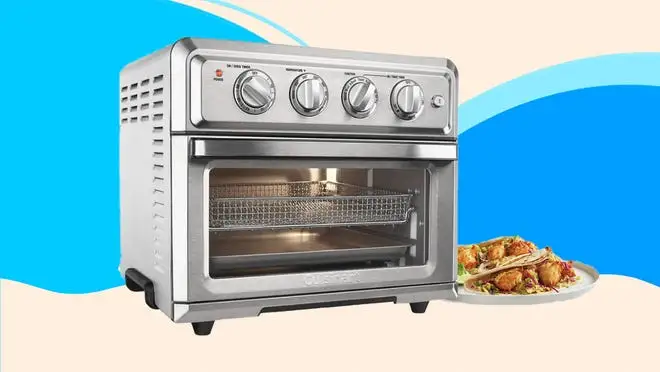 A stainless steel toaster oven against a blue background.