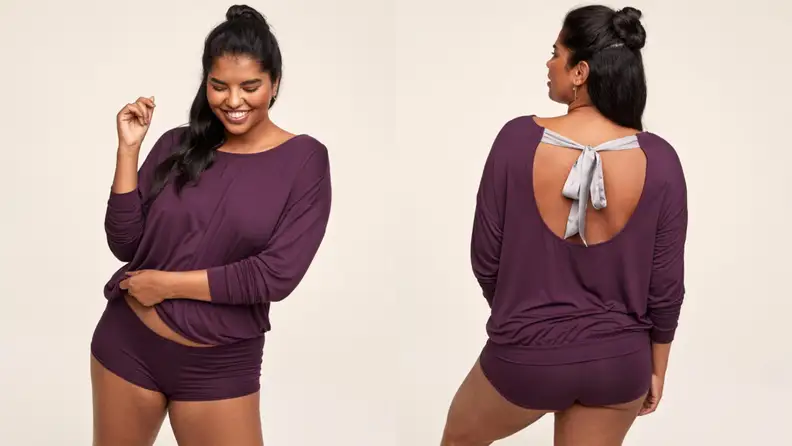 Woman wearing long sleeve shirt with bow in the back and shorts