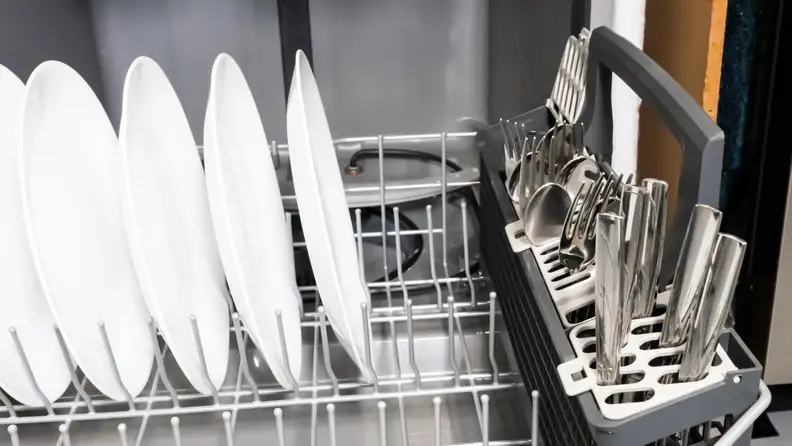 A close-up of the bottom rack, with plates and utensils loaded up for scale.