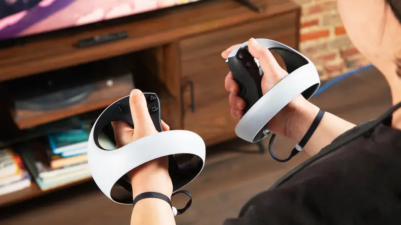 Two round VR controllers in hand for the playstation vr2