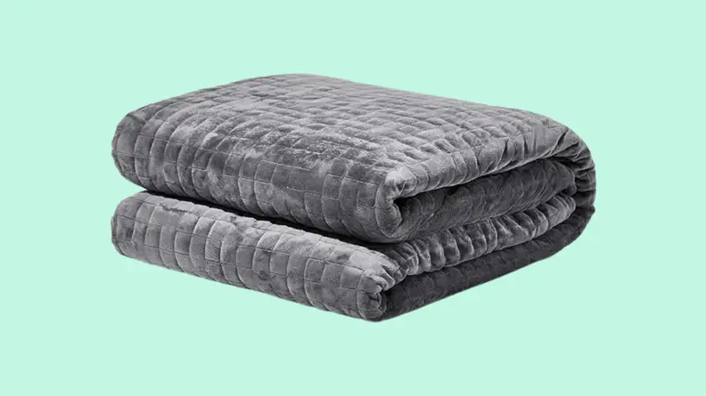Folded weighted blanket against blue background