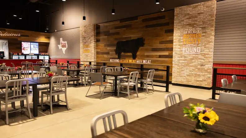 Seating area with BBQ-themed decor and "Nothing in Our Meat but Meat" wall art
